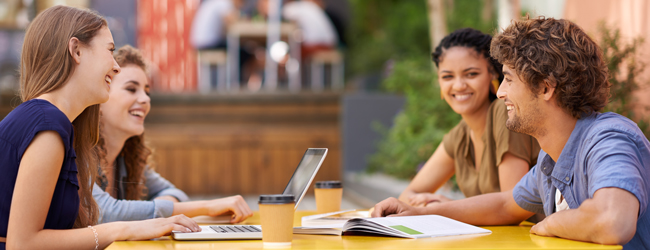 Sprachreisen als Bildungsurlaub in Ihrem Bundesland Vier Erwachsene sitzen an einem Tisch mit Tablets und lernen gemeinsam